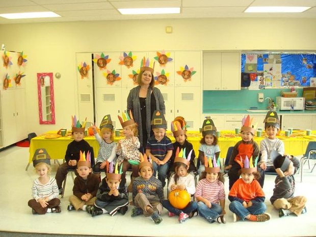 Ms. Simin with a group of Mills Montessori children at a Thanksgiving celebration